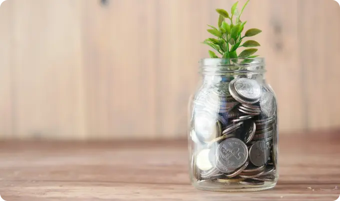 Jar of coins with grass growing out